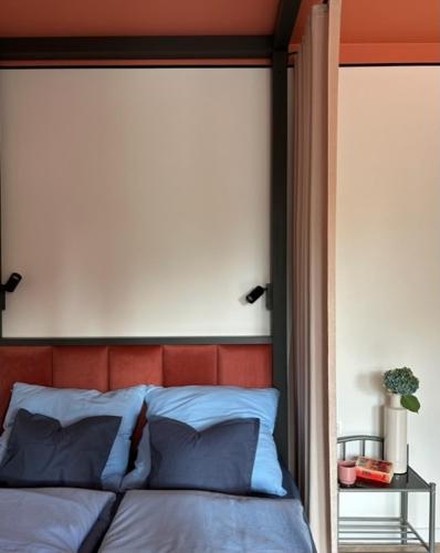 a bedroom with a bed with a red head board at Apartament TAMAJA in Bielsko-Biała