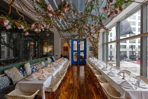 a row of tables in a room with windows at The Washington Hotel NYC in New York