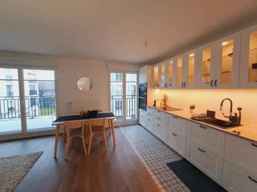 une grande cuisine avec une table et un évier dans l'établissement Cosy & Modern Flat Near Paris !, au Blanc-Mesnil