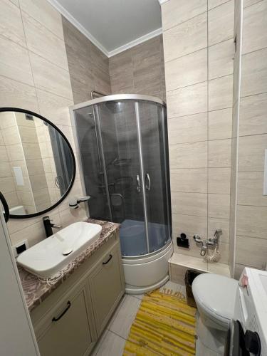 a bathroom with a shower and a sink and a mirror at Raduga Alfa in Chon-Sary-Oy