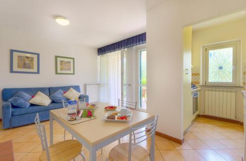 a living room with a table and a blue couch at Residence I Giardini Del Conero in Porto Recanati