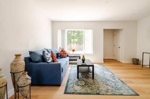 a living room with a blue couch and a rug at 1 Palo Alto - Fully Furnished, AC, Private, Parking & Laundry in East Palo Alto