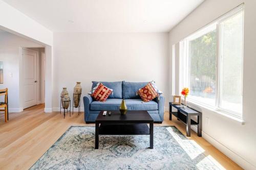a living room with a blue couch and a table at 1 Palo Alto - Fully Furnished, AC, Private, Parking & Laundry in East Palo Alto