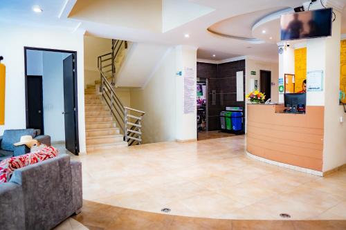 a living room with a couch and a staircase at KALINA HOTEL in Girardot