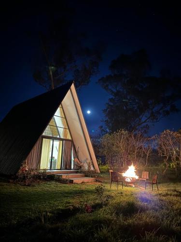 a cabin with a fire in the yard at night at Glamping Al Pie del Cerro in San Fernando