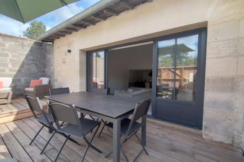 un patio avec une table et des chaises sur une terrasse dans l'établissement Maison en pierre rénovée, à Les Artigues-de-Lussac