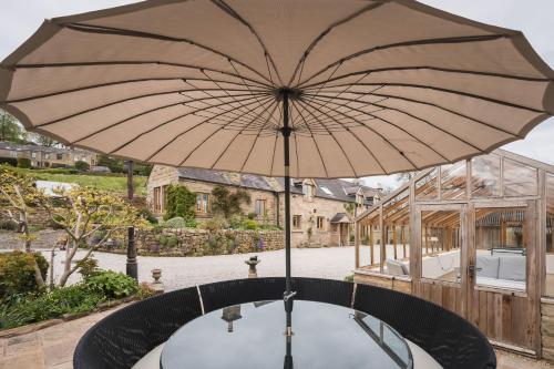 a large umbrella sitting on top of a table at Oker Farm - Luxury farmhouse with hot tub in the Peak District in Matlock