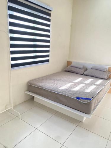 a bed sitting in a room with a window at Izz Homestay 6Pax 3R2B Puncak Alam in Bandar Puncak Alam