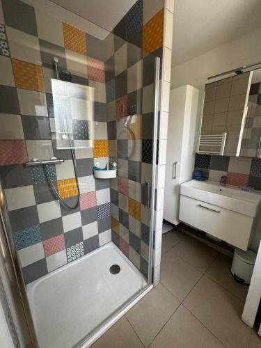 La salle de bains est pourvue d'une douche et d'un mur carrelé. dans l'établissement Maison a la plage, à Poggio-Mezzana