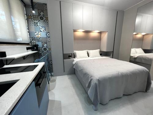 una camera d'albergo con un letto e una televisione di Golden Beach Suites a Sarandë