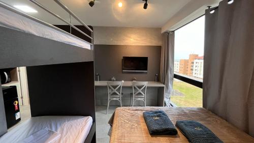 a bedroom with two bunk beds and a desk at Flat Premium Legacy Suites - Cabo Branco in João Pessoa