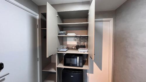 a walk in pantry with a microwave oven and a microwave at Flat Premium Legacy Suites - Cabo Branco in João Pessoa