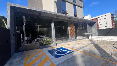 a building with a blue arrow on the ground in front of it at Flat Premium Legacy Suites - Cabo Branco in João Pessoa