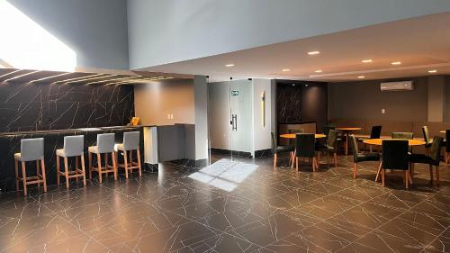 a restaurant with tables and chairs and a bar at Flat Premium Legacy Suites - Cabo Branco in João Pessoa