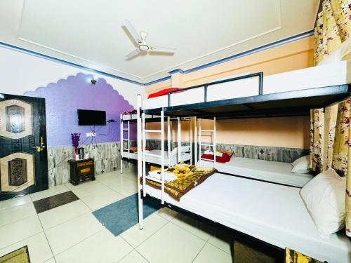 a bedroom with two bunk beds and a tv at MOONLIGHT HOMESTAY & HOSTEL in Jaipur