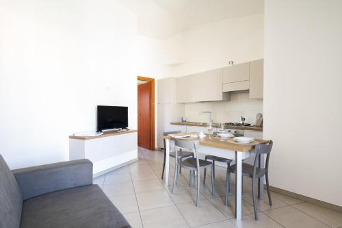 a kitchen and dining room with a table and chairs at Bernabé Apartment in Tortolì