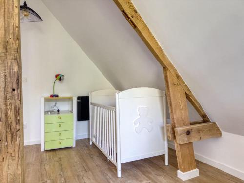 a attic room with a staircase and a dresser at Lampadaire du Martreuil Famille in Pierrefonds