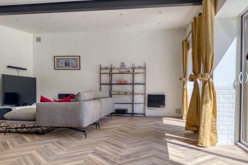 a living room with a couch and a television at Lampadaire du Martreuil Famille in Pierrefonds