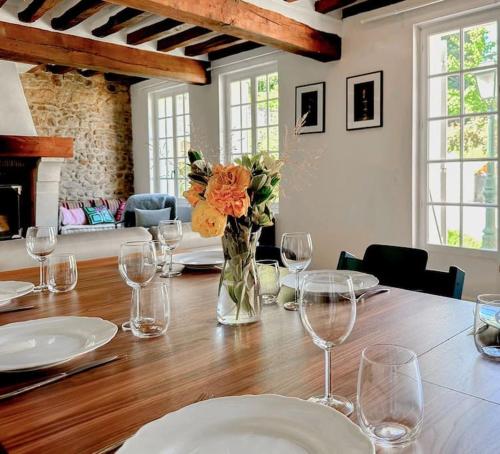 a table with glasses and a vase of flowers on it at Lampadaire du Martreuil Famille in Pierrefonds
