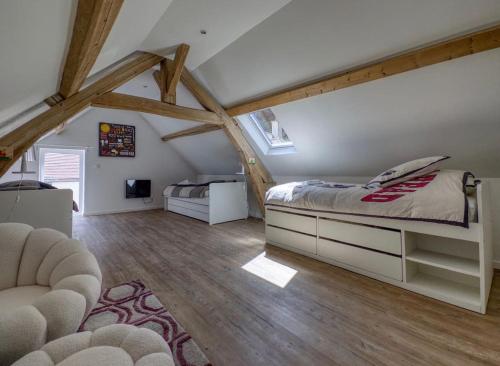 a bedroom with a bed and a couch in a attic at Lampadaire du Martreuil Famille in Pierrefonds
