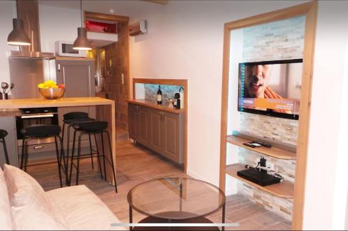 Il comprend un salon doté d'un canapé et une cuisine équipée d'une télévision. dans l'établissement Beau studio avec mezzanine, à Antibes