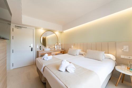 two beds in a hotel room with a mirror at Bordoy Cosmopolitan in Playa de Palma