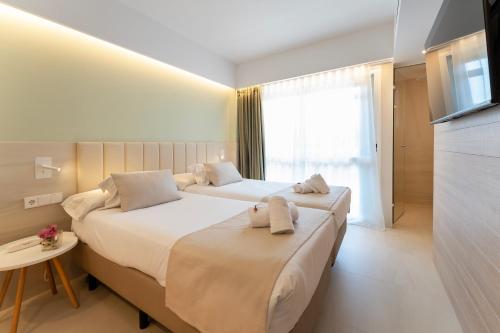 a hotel room with two beds with towels on them at Bordoy Cosmopolitan in Playa de Palma