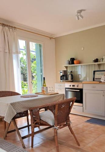 Il comprend une cuisine avec une table, des chaises et une table. dans l'établissement Maisonnette l'Olivier Bleu, à Nantes