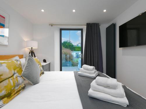 een slaapkamer met een wit bed met handdoeken erop bij Avon Cottage in St Ives
