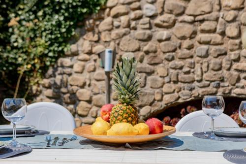 a plate of fruit on a table with wine glasses at H11 OASI SERENA Parcheggio-Giardino in Taggia