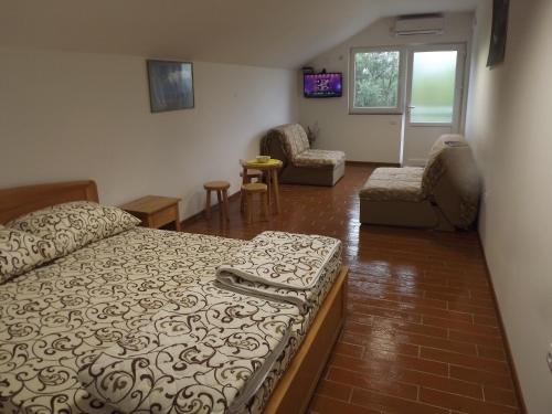 a bedroom with a bed and a living room with chairs at Guest House Zasavica in Zasavica Druga