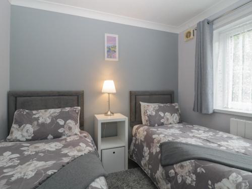 a bedroom with two beds next to a window at Flat 4, Big Tree Holiday Flats in Paignton