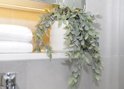 a green ivy wreath on a shelf in a bathroom at Luxury Apt w Wifi & Pvt parking in Chertsey