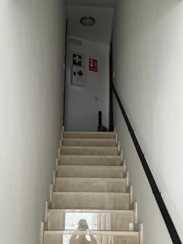 a person walking down a staircase with a person standing on it at Apartamentos Peñaflor in Guadix