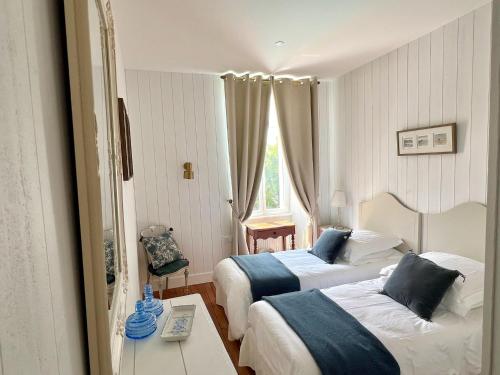 une chambre d'hôtel avec deux lits et une table dans l'établissement Le Relais du Puy, à Saint-Fulgent