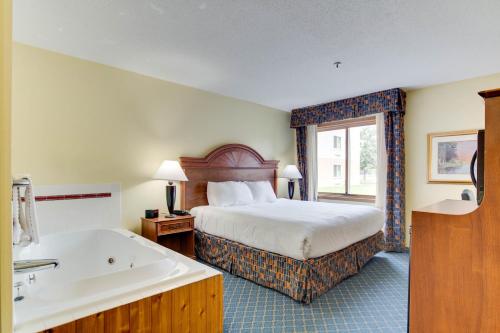 a hotel room with a bed and a bath tub at Hotel Bemidji in Bemidji