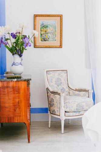 a chair and a vase with flowers on a table at Bastide Rose in Le Thor
