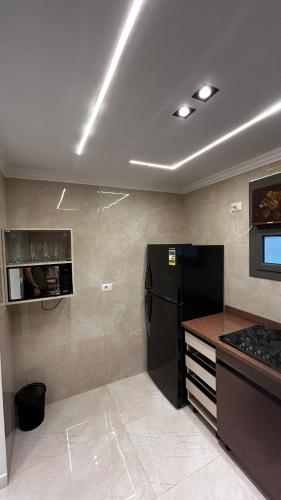 a kitchen with a black refrigerator and a stove at Avenu Al-3rab Hotel in Cairo