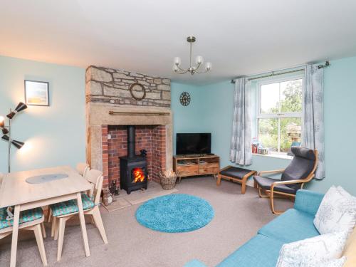 a living room with a fireplace and a couch at Woodcutters Cottage in Haltwhistle