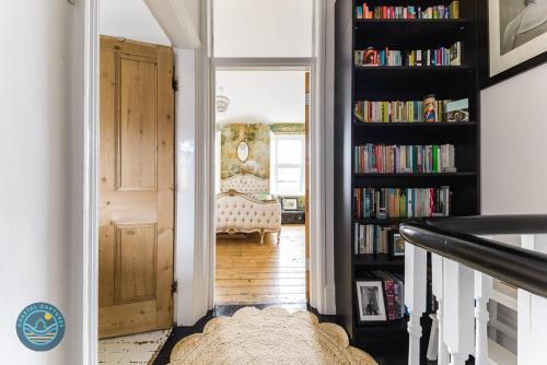 a hallway with a book shelf filled with books at Oneonesevenns Coastal Property in North Shields