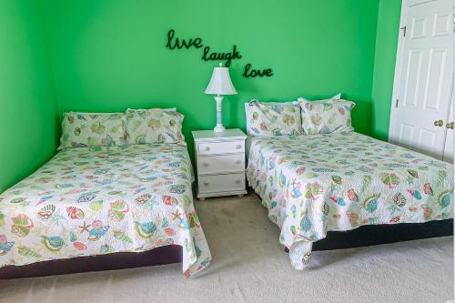 two beds in a room with green walls at Sunset Island - 35 Seaside in Ocean City