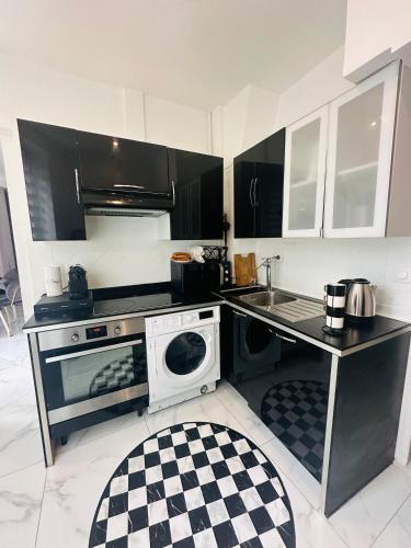 une cuisine avec une cuisinière, un évier et un micro-ondes dans l'établissement Appartement parisien, à Paris