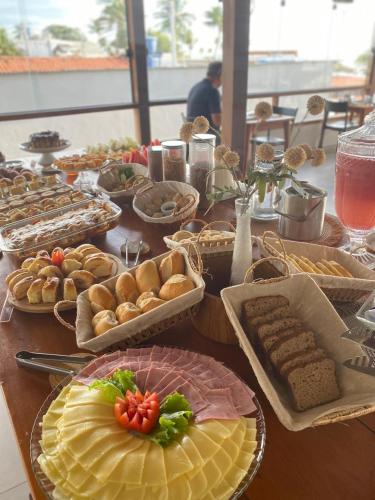 a table with many plates of food on it at Terra Bella Pousada in Morro de São Paulo