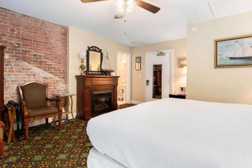 a bedroom with a bed and a brick wall at Old Brick Inn in Saint Michaels