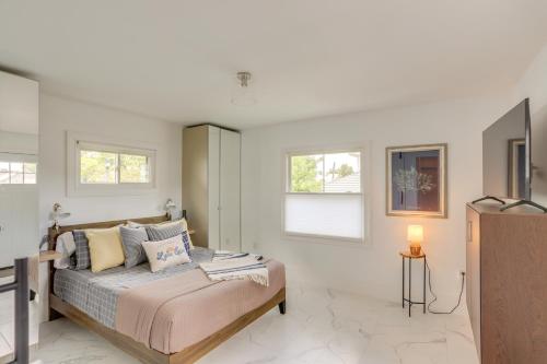 a bedroom with a bed and a tv and windows at Port Clinton Home with Lake View - Walk to Beach! in Port Clinton