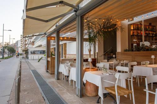 a restaurant with white tables and chairs on a street at Hostal Olga in Sant Antoni de Calonge