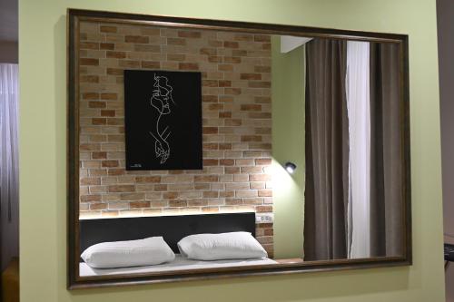 a mirror on a brick wall with two pillows at Station 44 Apartments in Bitola