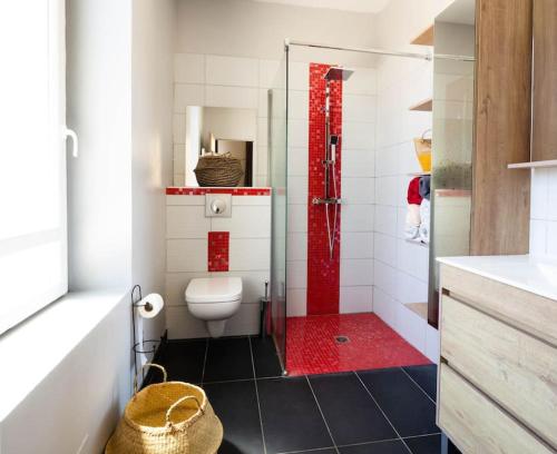 La salle de bains est pourvue de toilettes et d'une douche rouge. dans l'établissement Duplex moderne centre Narbonne, à Narbonne