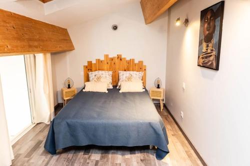 une chambre avec un grand lit avec une tête de lit en bois dans l'établissement Duplex moderne centre Narbonne, à Narbonne