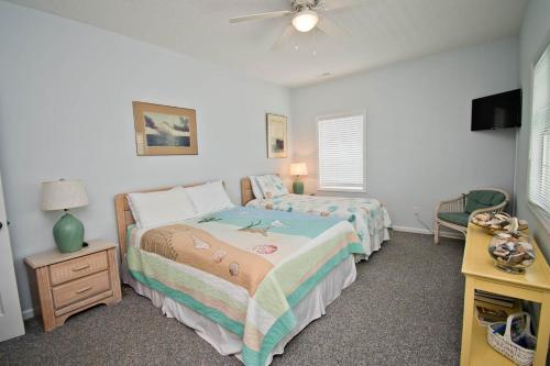 a bedroom with two beds and a ceiling fan at Great Expectations West in Emerald Isle